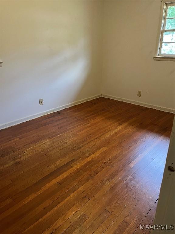 empty room with dark wood-type flooring