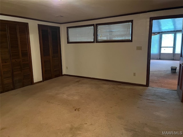 unfurnished bedroom with two closets and carpet floors