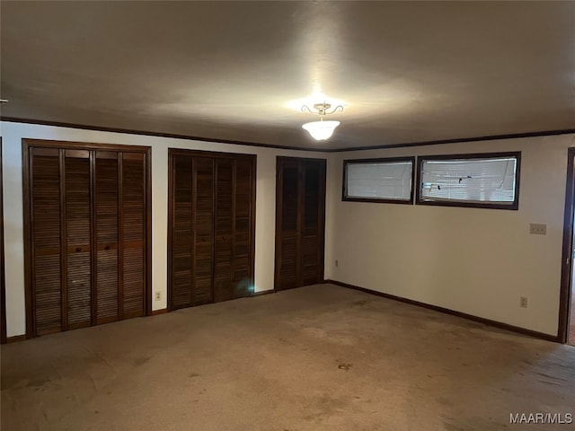 unfurnished bedroom with carpet floors and multiple closets