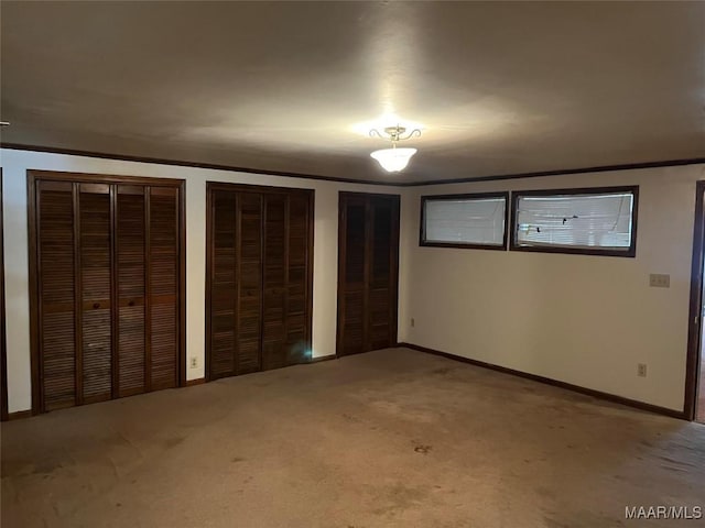 unfurnished bedroom featuring multiple closets and carpet