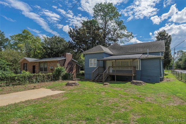 rear view of property featuring a lawn