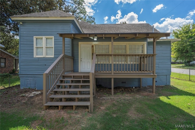 rear view of property featuring a yard