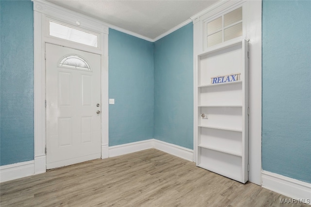 foyer entrance featuring light hardwood / wood-style flooring and ornamental molding