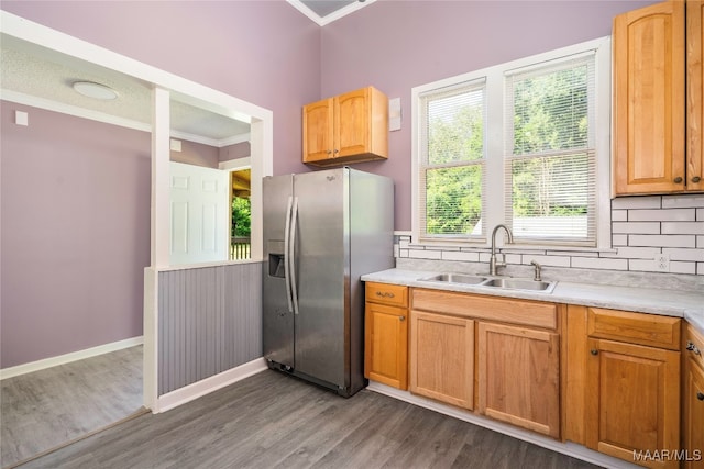 kitchen with dark wood-type flooring, sink, stainless steel refrigerator with ice dispenser, crown molding, and backsplash