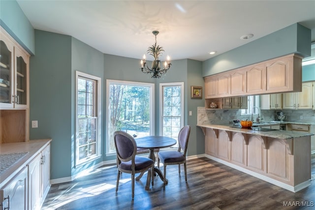 kitchen featuring dark wood-style floors, a breakfast bar, baseboards, and decorative backsplash