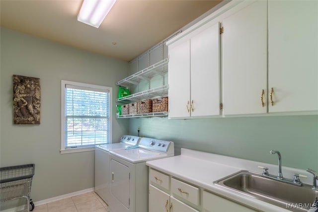 laundry room featuring cabinet space, baseboards, separate washer and dryer, a sink, and light tile patterned flooring