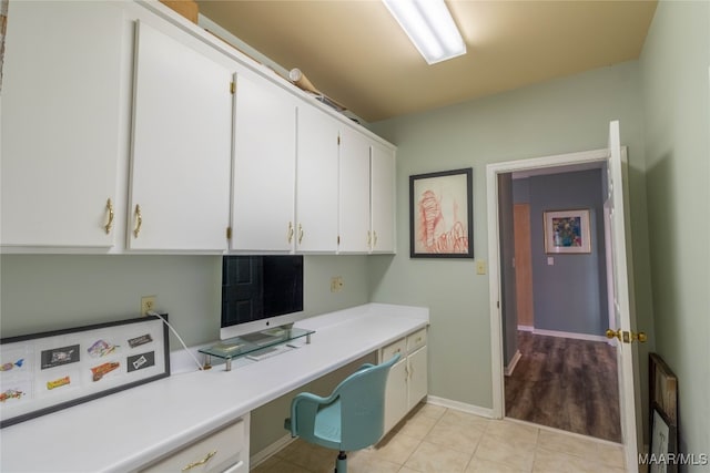 office featuring light tile patterned flooring, built in study area, and baseboards