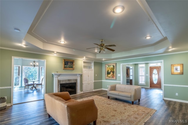 living area featuring a tray ceiling, plenty of natural light, and wood finished floors