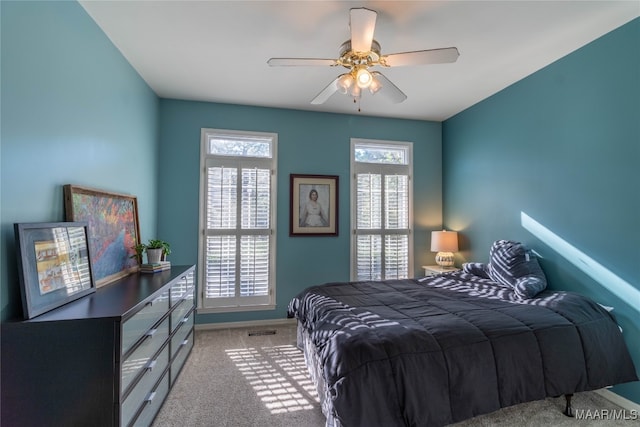 bedroom with a ceiling fan, carpet flooring, visible vents, and baseboards