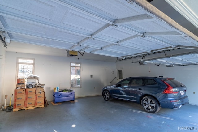 garage featuring electric panel, baseboards, and a garage door opener