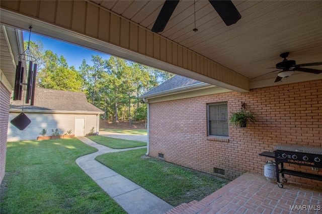 view of side of home with brick siding, a ceiling fan, a yard, crawl space, and roof with shingles