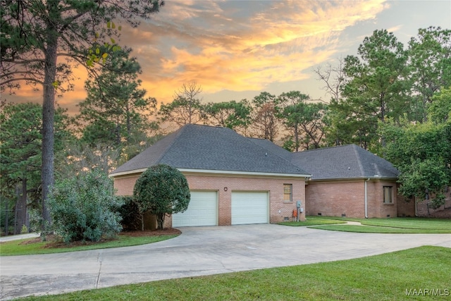 ranch-style house with a front yard, crawl space, driveway, and an attached garage