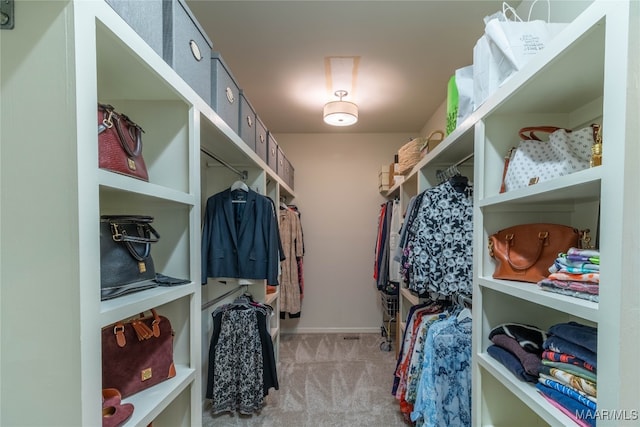 walk in closet featuring light carpet