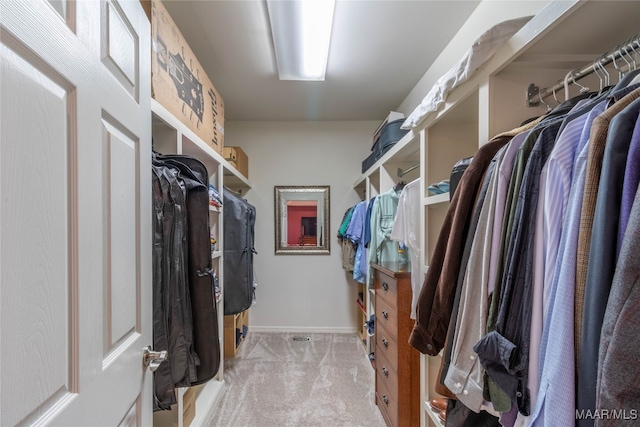 walk in closet with light carpet