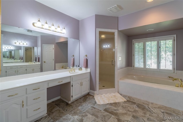 bathroom with a stall shower, visible vents, a bath, and vanity