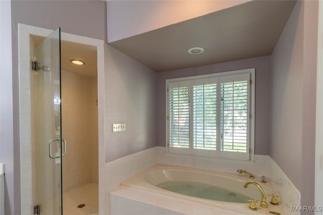 bathroom with a shower stall and a bath