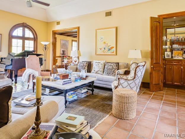 living room featuring light tile patterned flooring, visible vents, and ceiling fan