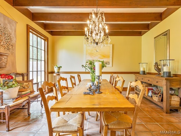 tiled dining area featuring beamed ceiling and a chandelier