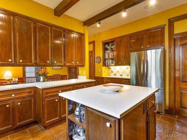 kitchen featuring decorative backsplash, dark tile patterned floors, freestanding refrigerator, open shelves, and light countertops