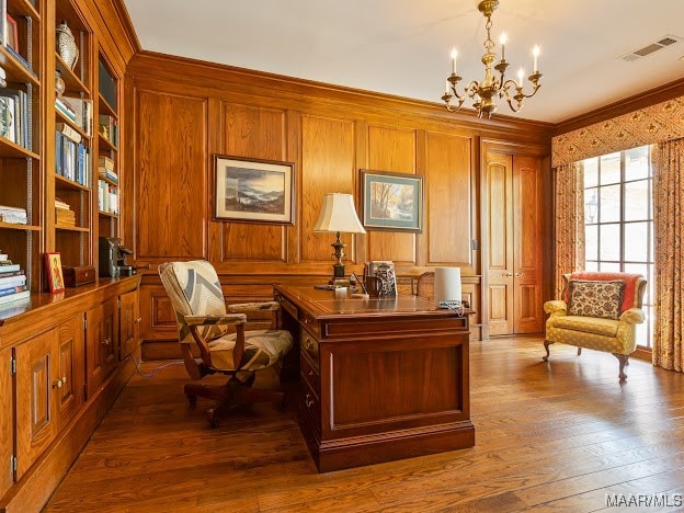 home office featuring hardwood / wood-style flooring, a notable chandelier, crown molding, and wooden walls