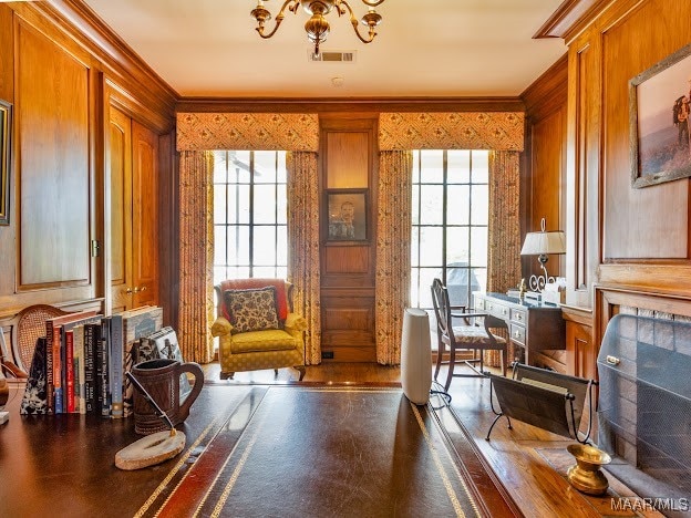 home office featuring ornamental molding, plenty of natural light, wood walls, and hardwood / wood-style floors