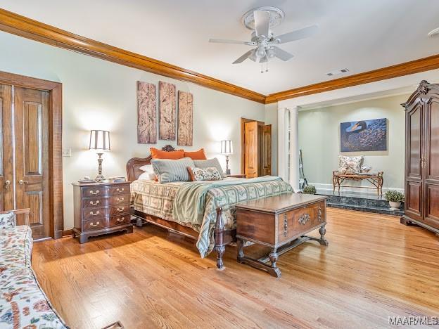bedroom featuring ornamental molding, visible vents, and light wood-style floors
