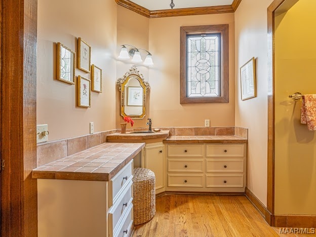 bathroom with crown molding, vanity, and wood-type flooring