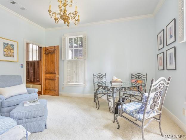 carpeted dining room featuring baseboards, visible vents, an inviting chandelier, and crown molding