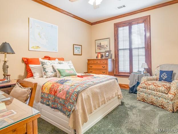 carpeted bedroom with visible vents, crown molding, a ceiling fan, and multiple windows