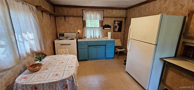 kitchen featuring blue cabinets, washer / clothes dryer, light floors, and freestanding refrigerator