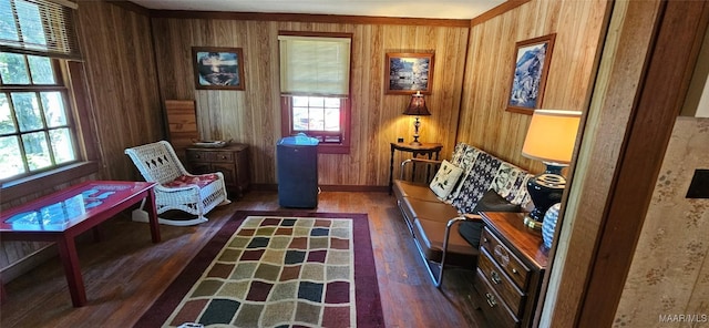 sitting room with wooden walls, wood finished floors, and baseboards