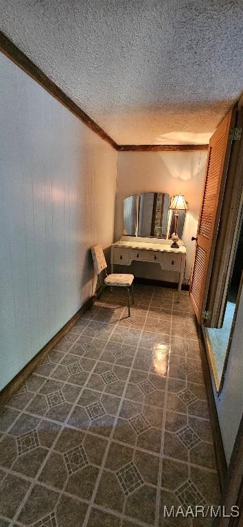interior space with ornamental molding and a textured ceiling