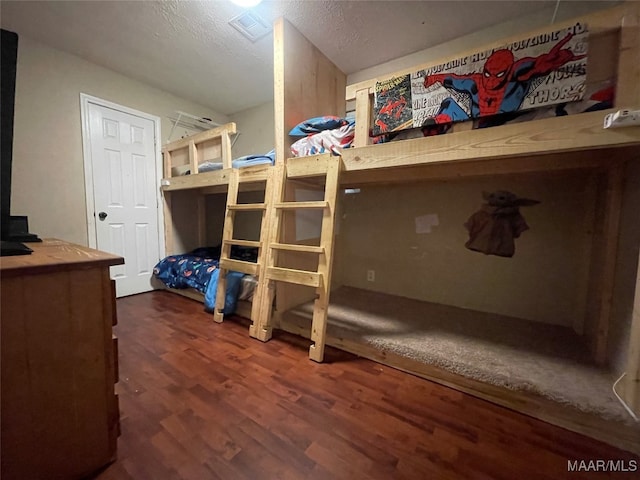 bedroom featuring dark wood-type flooring and a textured ceiling