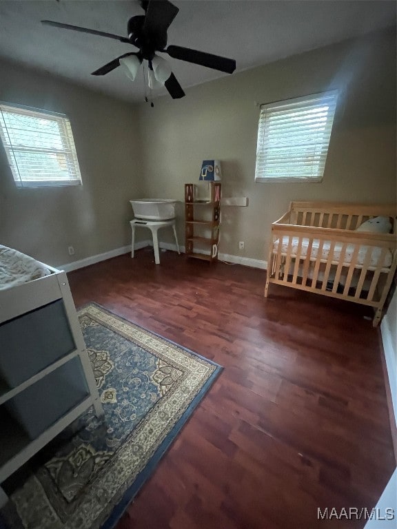 bedroom with dark hardwood / wood-style flooring and ceiling fan