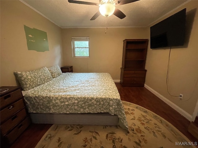 bedroom featuring ceiling fan, a textured ceiling, dark hardwood / wood-style floors, and crown molding