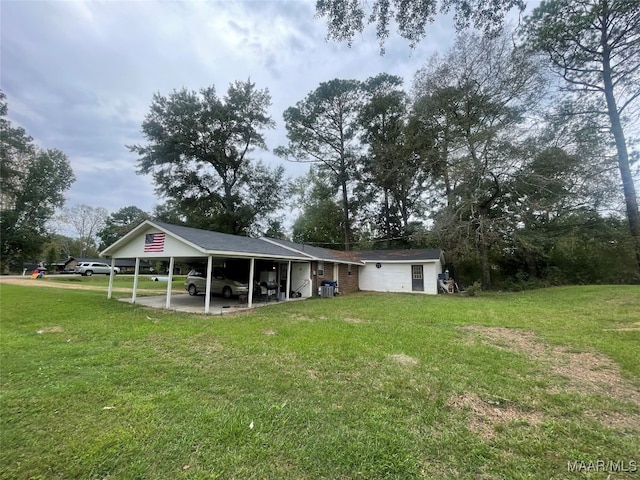 rear view of house with a lawn and a carport