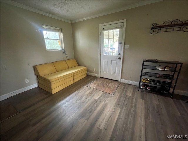 entrance foyer featuring hardwood / wood-style flooring, ornamental molding, a textured ceiling, and a wealth of natural light