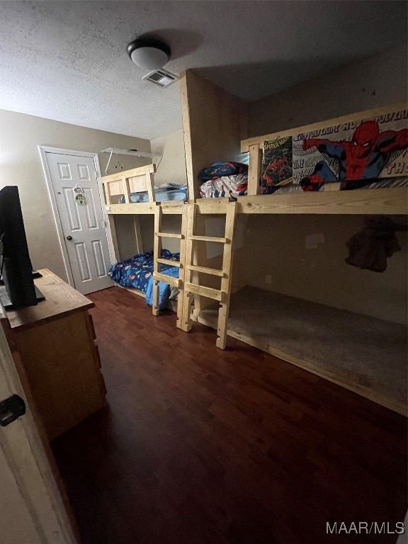 bedroom featuring dark hardwood / wood-style floors and a textured ceiling