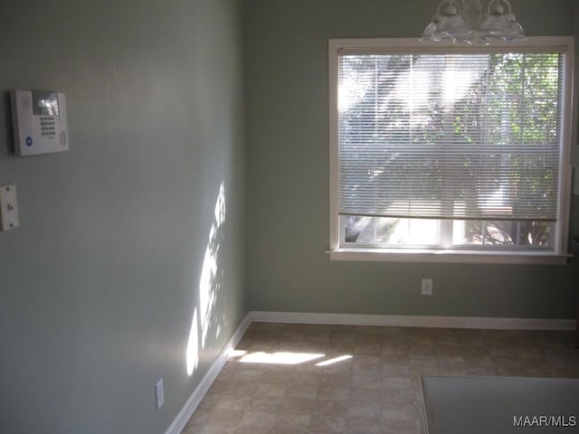 empty room featuring an inviting chandelier