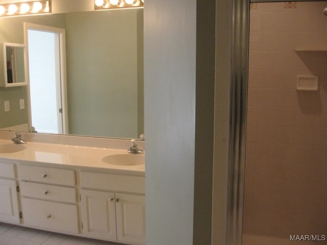 bathroom with vanity, a shower with shower door, and tile patterned floors