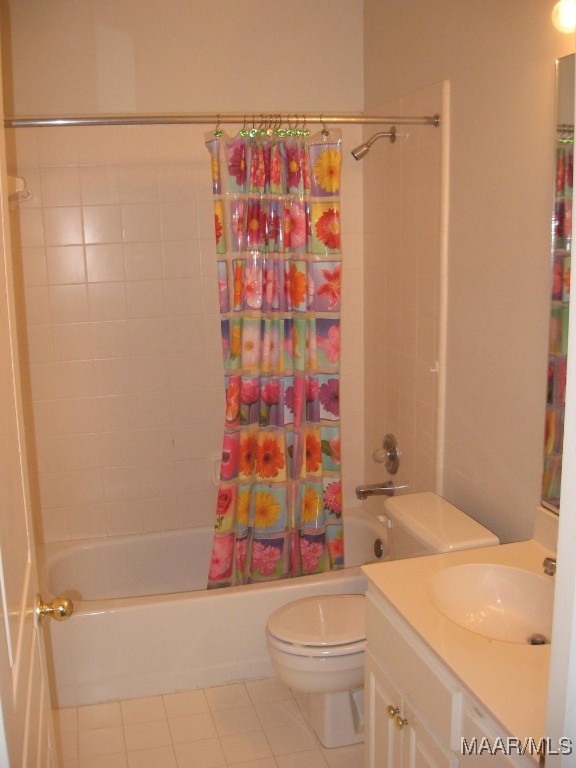 full bathroom with tile patterned flooring, toilet, shower / bath combo with shower curtain, and vanity