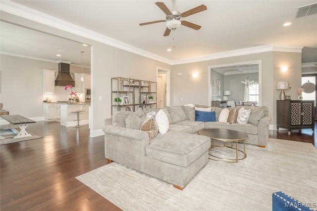 living room with ceiling fan with notable chandelier, dark hardwood / wood-style floors, and ornamental molding