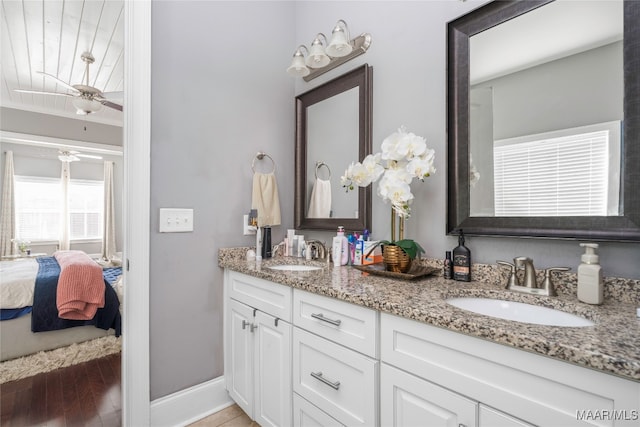 bathroom with hardwood / wood-style floors, ceiling fan, and vanity