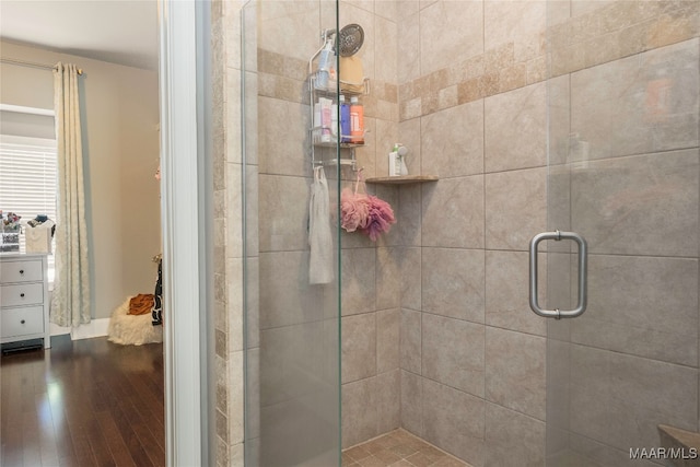 bathroom with wood-type flooring and a shower with door