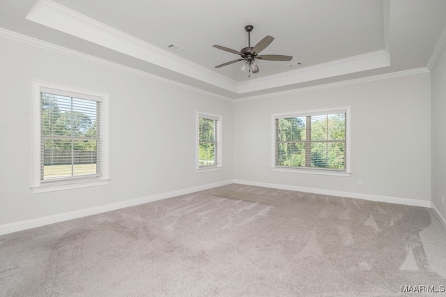 carpeted empty room featuring ceiling fan, crown molding, and a tray ceiling