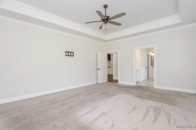 unfurnished bedroom featuring light carpet, crown molding, ceiling fan, and a raised ceiling