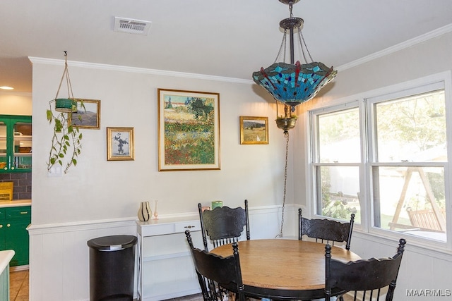 dining space with crown molding, a chandelier, and light tile patterned floors