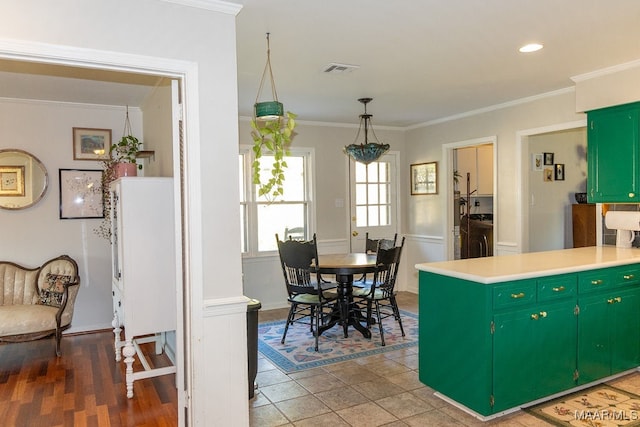 kitchen featuring ornamental molding, green cabinets, and dark wood-type flooring