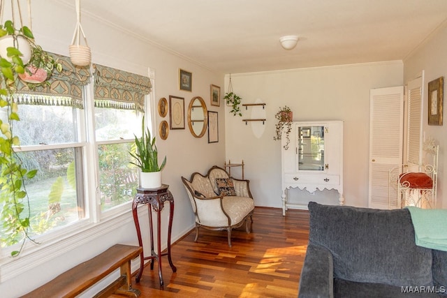 living area with crown molding and dark hardwood / wood-style flooring