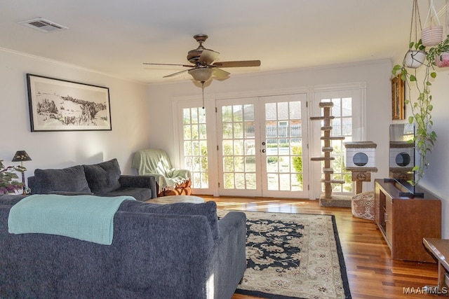 living room featuring hardwood / wood-style flooring, crown molding, ceiling fan, and french doors